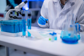 Fototapeta premium Scientist analyzing samples in petri dishes using micropipette in laboratory