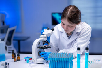 Scientist using microscope analyzing samples in laboratory researching new medicine or vaccine