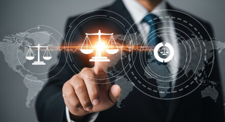 Professional man in a suit touching an icon of the scales of justice overlaid on a world map, symbolizing legal and global concepts in soft lighting.