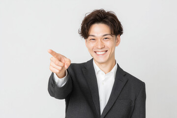 笑顔で指差す若いビジネスマン