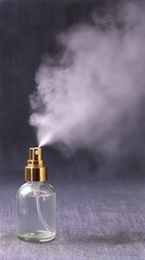 A clear glass spray bottle releasing vapor on a textured gray surface with a dark background