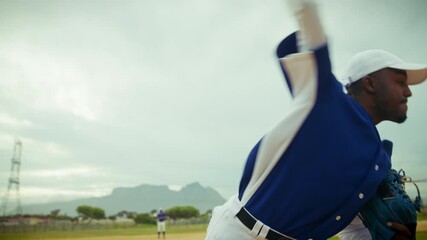 A focused baseball pitcher winds up and throws a fastball on the mound, demonstrating athletic skill and dedication during the game. - Powered by Adobe