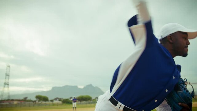 A focused baseball pitcher winds up and throws a fastball on the mound, demonstrating athletic skill and dedication during the game.