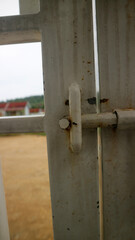 Rusty Metal Latch on White Gate