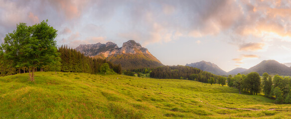 Fototapeta premium Meadow with road and bench during sunset in Berchtesgaden National Park
