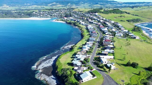Drone aerial landscape of rural town streets with residential homes along main road headland coastline of Gerroa near the Crooked River inlet in Illawarra South Coast Australia holiday travel outdoors
