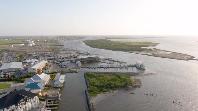 A smooth forward drone flight over Grand Isle and Bayou Fifi, revealing the marina, boats, industrial facilities, and the natural, undeveloped landscape of Fifi Island along the Louisiana coast