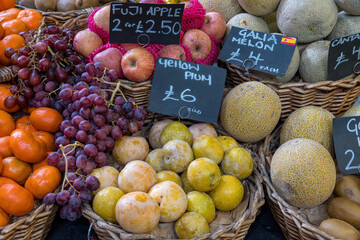 Plums, apples and melons for sale at a market