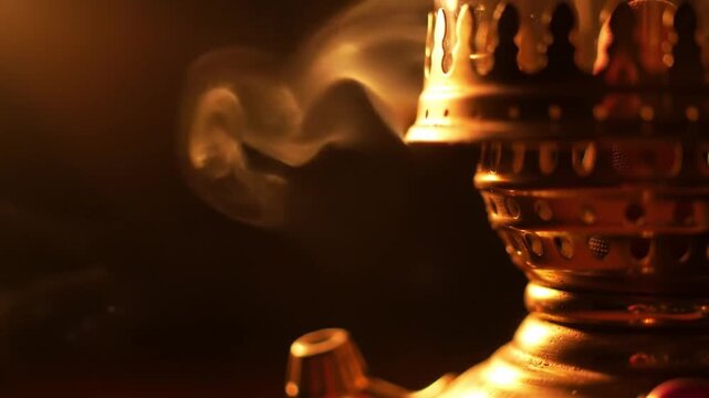 Close up of ornate hookah with smoke against a dark background
