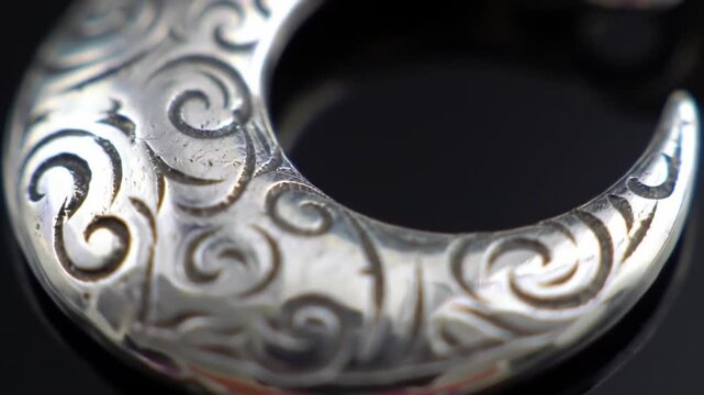 Close up of ornate silver jewelry with intricate engraved patterns