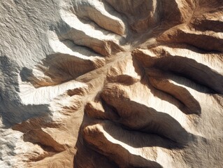 Aerial view of rugged desert canyon formations with deep shadows, carved ridges, and warm natural earth textures