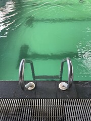Refreshing Green Pool Water with Ladder