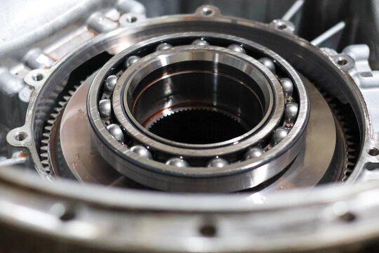A close-up view of a large, high-precision radial ball bearing and internal gears inside an open automotive or industrial metal gearbox housing ready for assembly or repair.
