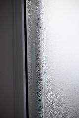 Condensation appears on the inside of a window pane. Water droplets have formed due to humidity and lack of proper ventilation inside the House.