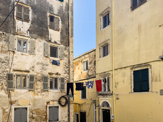 Laundry hangs above the alley in Corfu old town, Greece. Traditional architecture buildings.