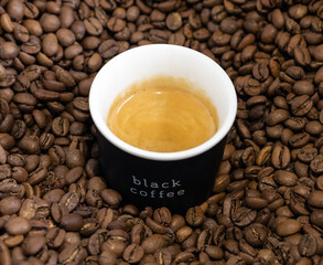 A cup of coffee over beans. Black coffee aroma. 
