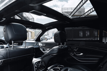 Luxury car interior showcasing a panoramic sunroof in an urban setting