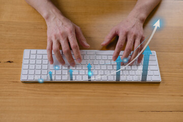 Businessman’s hands typing on keyboard with glowing arrows and graph lines, symbolizing business growth, data analytics, digital marketing strategy online success concept.