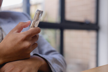 Close-up of hand holding smartphone with clear case, representing mobile communication, technology usage, digital lifestyle online connectivity in modern society.