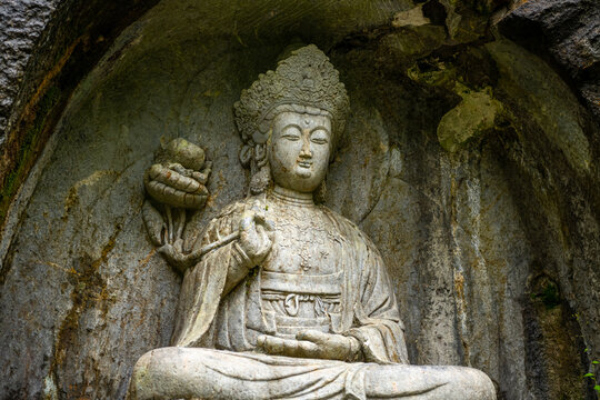 the stone statue avalokitesvara made in Yuan Dynasty from Peak Flown From Afar Fei Lai Fen, Ling Jiu Feng , stands next to Lingyin Temple Hangzhou China
