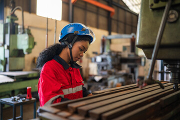 Portrait of female automation engineer standing in modern industrial factory and working in...