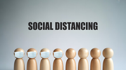 Simple wooden figures wearing protective masks clearly demonstrate essential social distancing protocol for public safety awareness