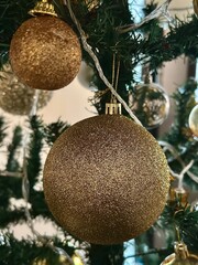 Christmas gold and silver ornaments hanging on a Christmas tree