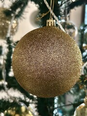 Beautiful and elegant Christmas background of gold ornament hanging on a Christmas tree.
