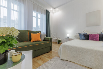 Cozy Bright Room with Green Sofa and Soft Bedding