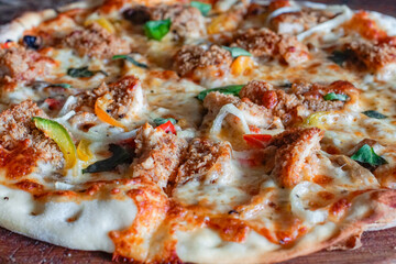 Macro close-up of crispy chicken pizza with melted cheese, peppers, onions, and basil. Warm, appetizing texture perfect for menus, ads, food blogs, and restaurant branding