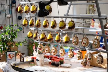 Painting handmade decorative Christmas tree decorations in an art studio with vibrant patterns