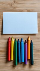 Vibrant photo of Blank white card with colorful crayons on a wooden table