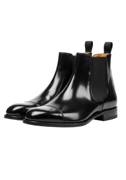 A low-angle shot of pristine black high-polish italian leather men's chelsea boots with goodyear welt stitching on a transparent studio background, dramatic rim lighting. Concept for luxury