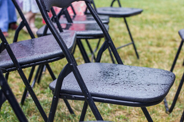 Empty outdoor event seating suggesting cancellation due to wet weather