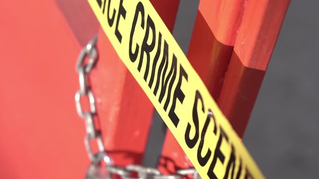 Crime Scene Police Tape on Metal Door With Lock and Chain, Close Up