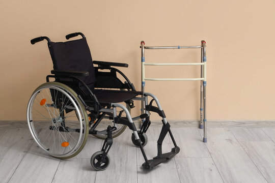 Medical walker with wheelchair near beige wall in room