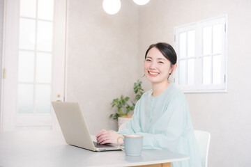 自宅やカフェでパソコンをする笑顔のかわいい女性　　カメラ目線	