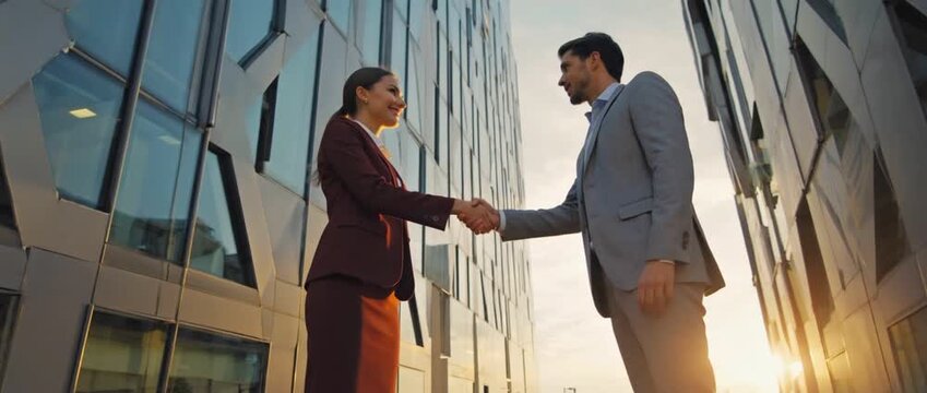 Partnership handshake: Two business professionals seal a deal with a firm handshake. set against the backdrop of a modern urban landscape. It's a symbol of collaboration, trust, and shared success.