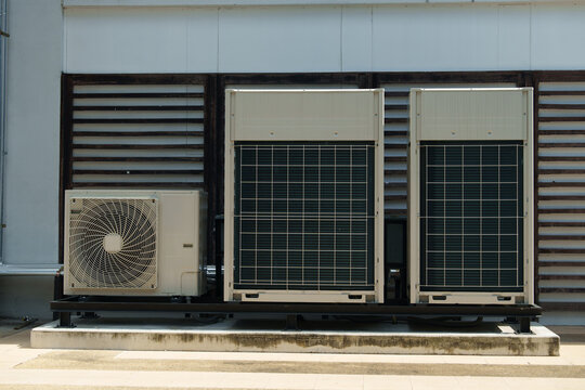 Air compressor or air condenser unit located on support outside building to heat released transferred to surrounding environment, Compressor is part of cooling function and air conditioning HVAC syste