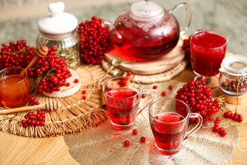 Cups of tasty viburnum tea on table in living room