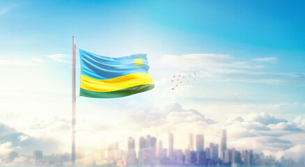 Rwanda flag wavering in beautiful clouds with building skyline. The flag with drone shot in...