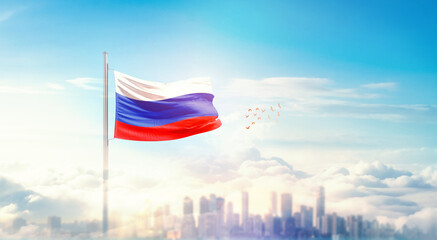 Russia flag wavering in beautiful clouds with building skyline. The flag with drone shot in beautiful sky. Russia national flag for independence day.
