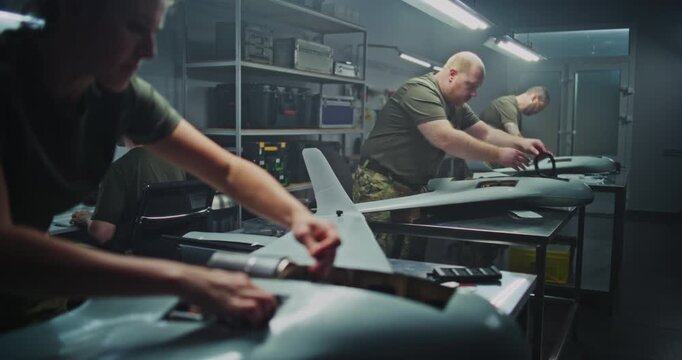 Woman Engineer in Military Uniform Meticulously Installs Internal Components Into Large, Strategic Surveillance UAV. Concept of Professional Expertise and Crucial Role of Women in Defense Technology.