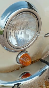 Close up on the headlight of a white vintage car. Action