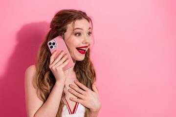 Elegant young woman enjoying phone conversation, expressing happiness, dressed stylishly against...