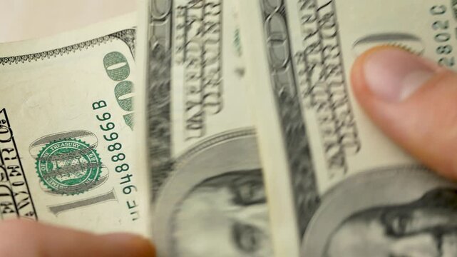 Fingers counting hundred dollar bills. Physical representation of economic power, enabling financial independence, market engagements, and structured investment planning, ensuring liquidity