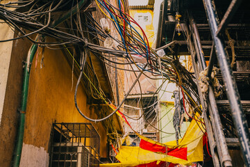 Mumbai's slums, notably Dharavi Old brick wall covered with tangled electrical cables in India. Decaying architecture, uncontrolled wiring and urban decay.