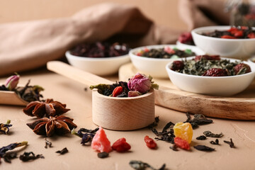 Scoop with dry fruit tea on beige grunge background, closeup