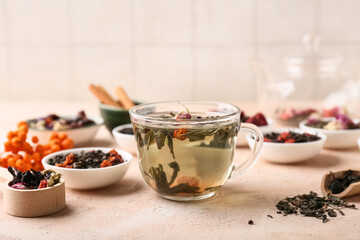 Bowl of dry fruit tea and cup of tea on pink grunge background, closeup