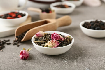 Bowl with dry fruit tea on grey grunge background, closeup